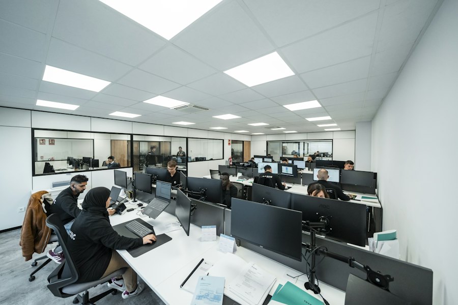 Kantoor met beeldschermwerkplekken onder LED-panelen